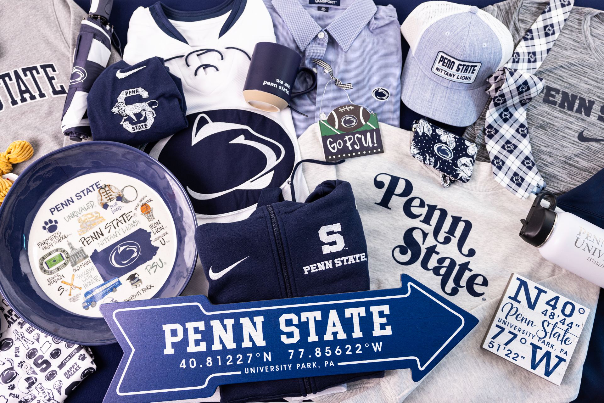 Grouping of Penn State licensed products including shirts, a hat, a sign, and a plate