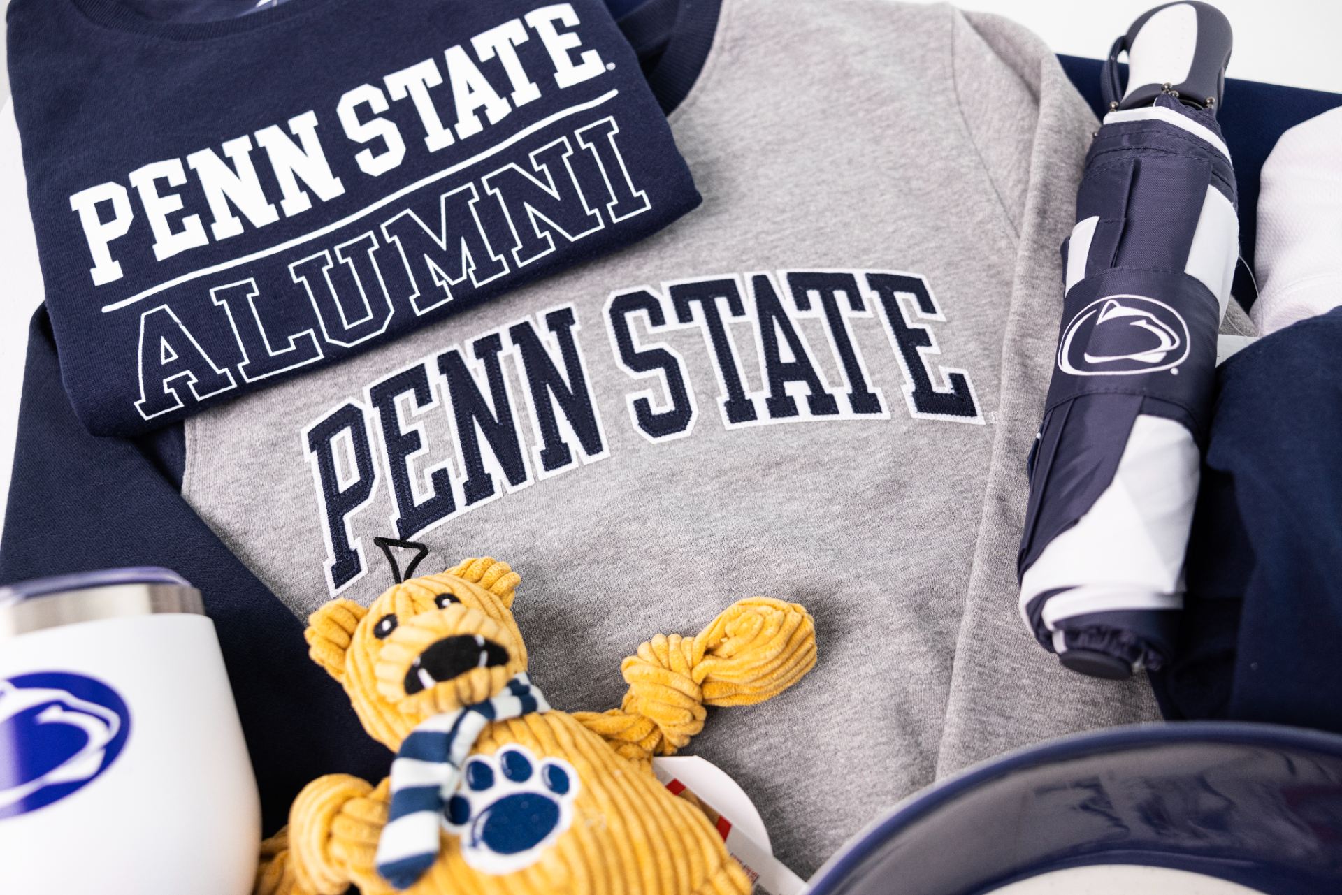 Penn State Alumni shirt, Pen State sweatshirt, Penn State cups, and a Nittany Lion stuffed animal